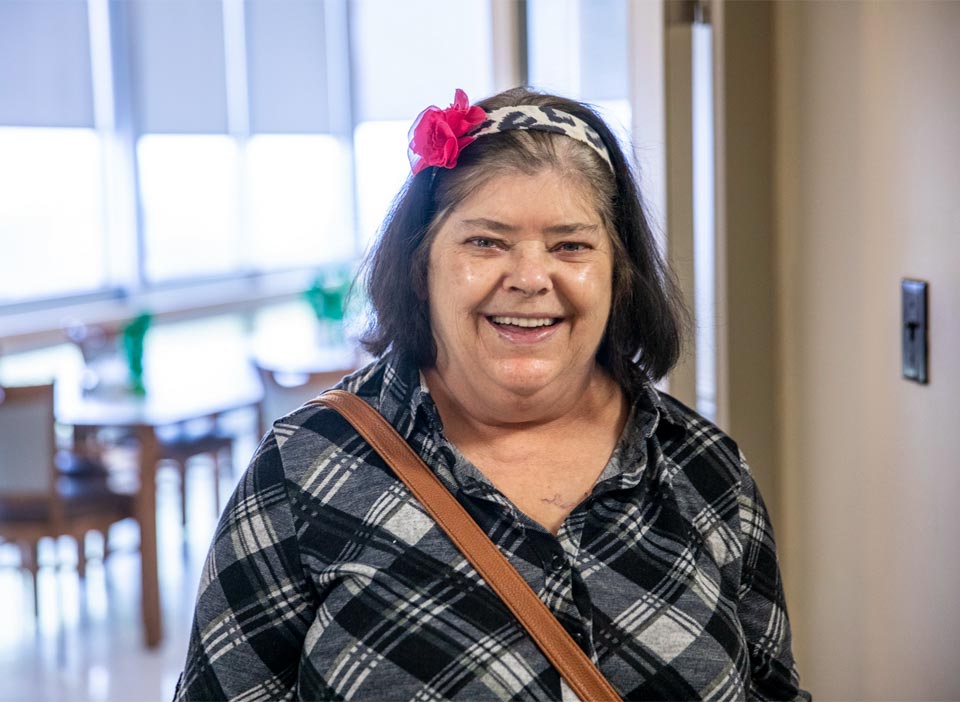 Older senior lady smiling in hallway