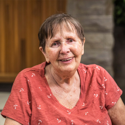 Elderly woman sits smiling