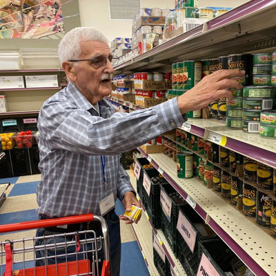 Volunteer takes grocery item from shelf