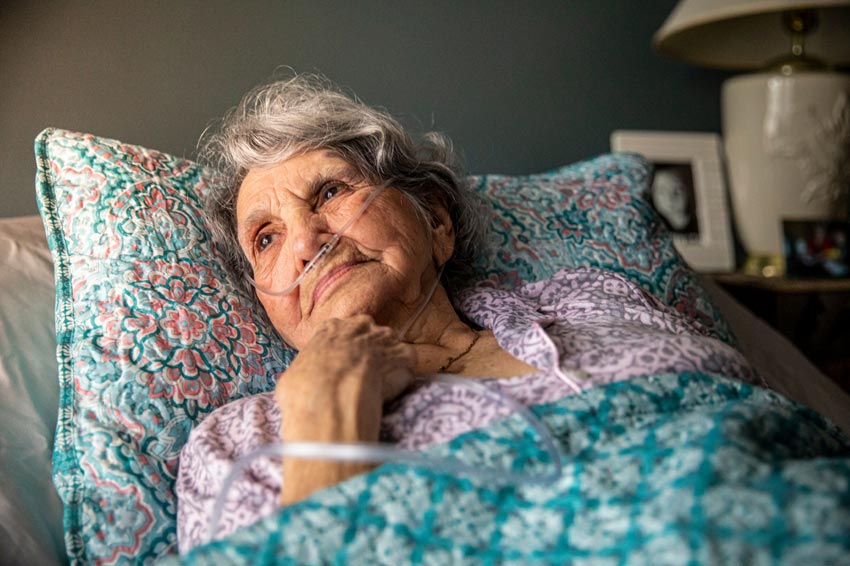 Elderly woman with oxygen laying in bed