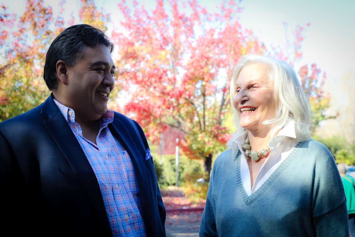 Man and woman standing outside talking and smiling
